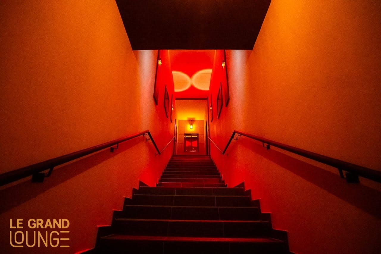 L'escalier d'entrée du Grand Lounge, baigné de lumière rouge